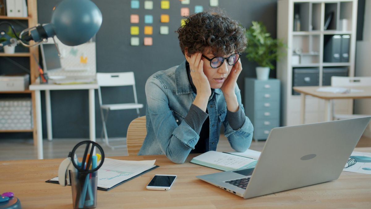 Erschöpfte Führungskraft Mitte 30 am Schreibtisch, symbolisch für Burnout-Risiko in der Lebensmitte